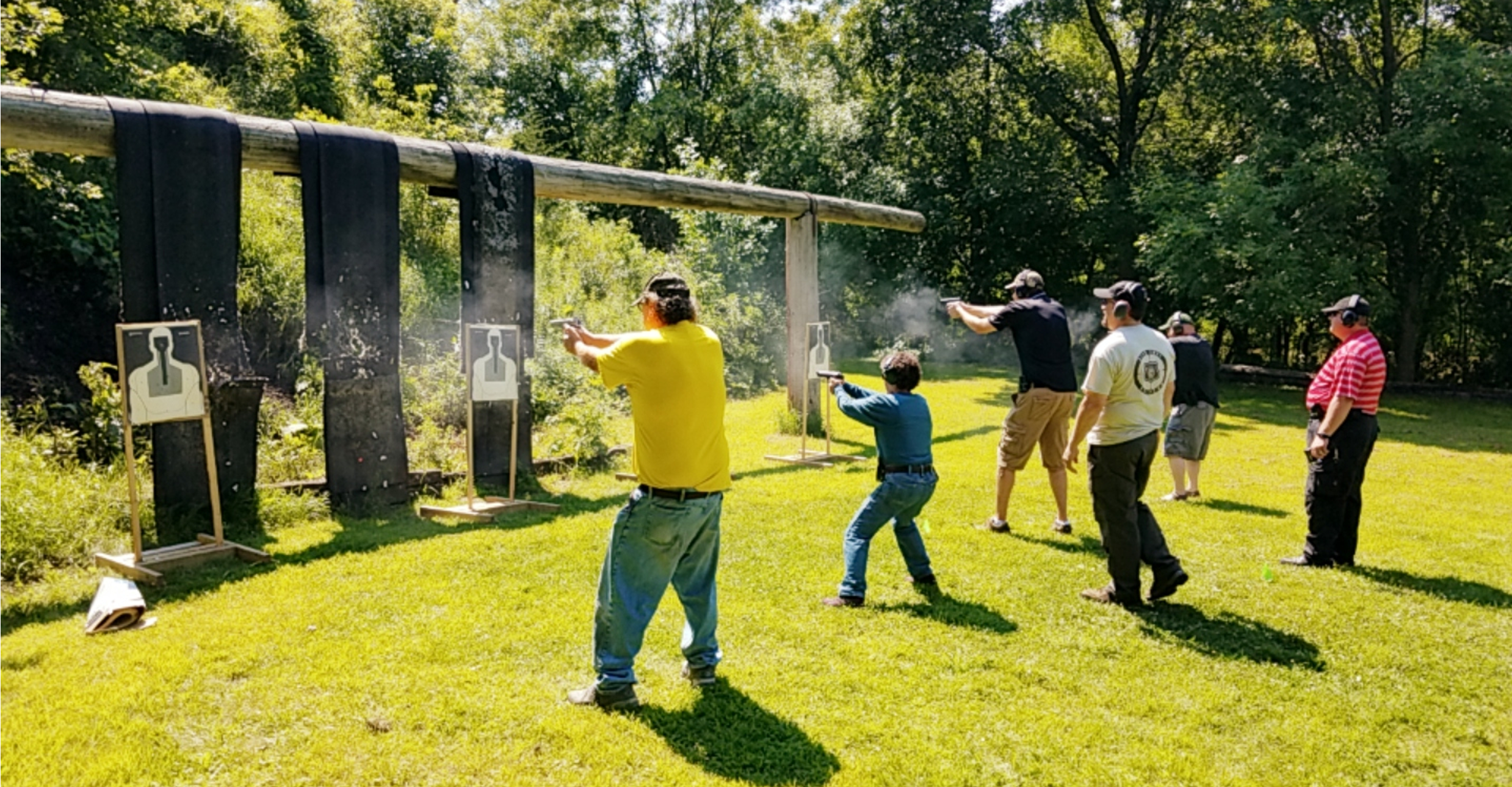 People practicing shooting at outdoor range