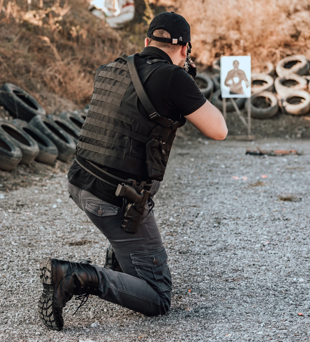 Man kneeling with gun in shooting stance